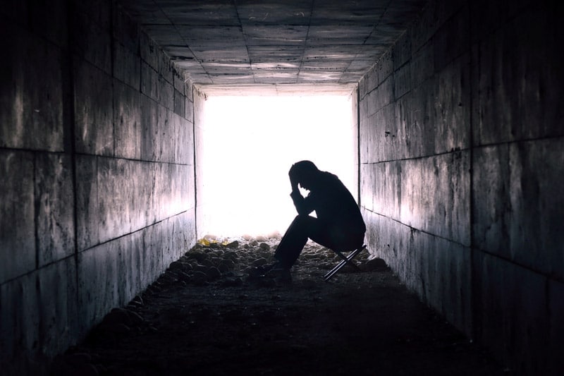 Depressed man sitting in the tunnel